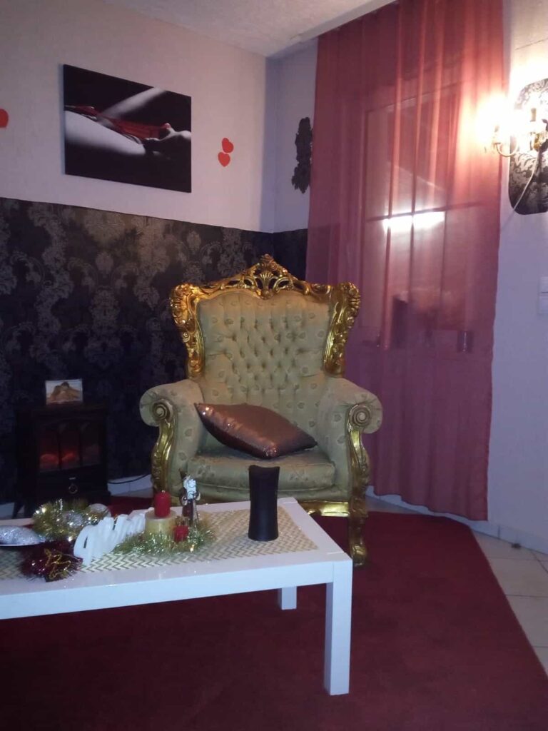 Goldener Thronsessel vor Ornamenttapete und rotem Vorhang